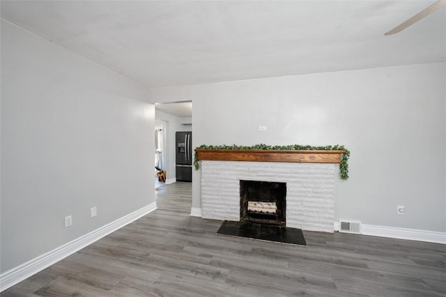 unfurnished living room featuring ceiling fan, a fireplace, and hardwood / wood-style floors