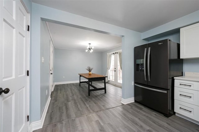 kitchen featuring hardwood / wood-style floors, white cabinets, french doors, and black fridge with ice dispenser