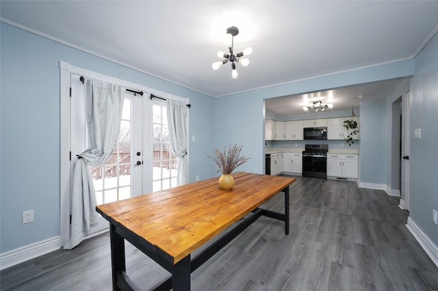 dining space featuring french doors, dark hardwood / wood-style flooring, ornamental molding, and a notable chandelier