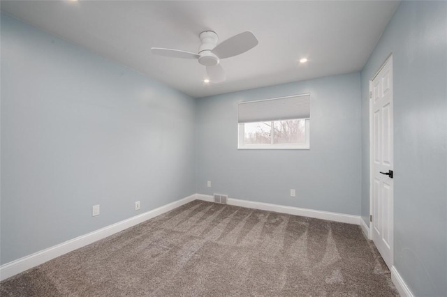 unfurnished room with ceiling fan and carpet