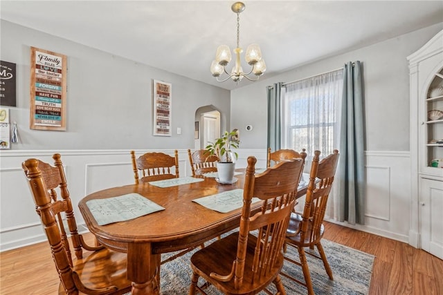 dining space with a notable chandelier and light hardwood / wood-style flooring