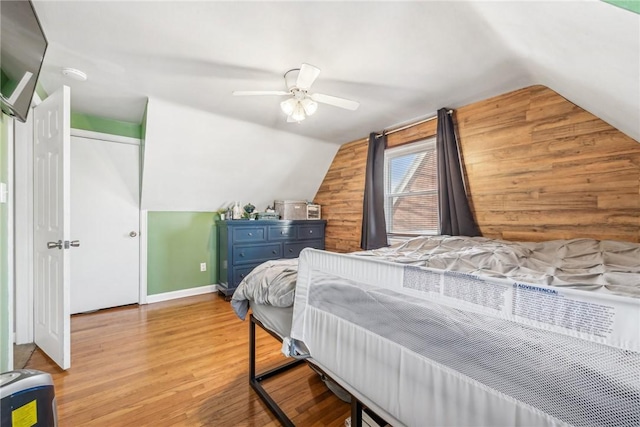 bedroom with ceiling fan, light wood-type flooring, and vaulted ceiling