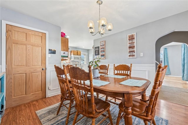 dining room featuring light wood-type flooring and a notable chandelier