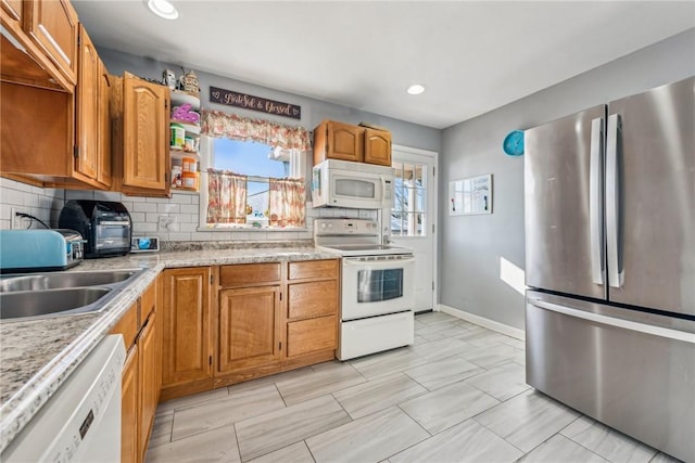 kitchen with white appliances, sink, and decorative backsplash