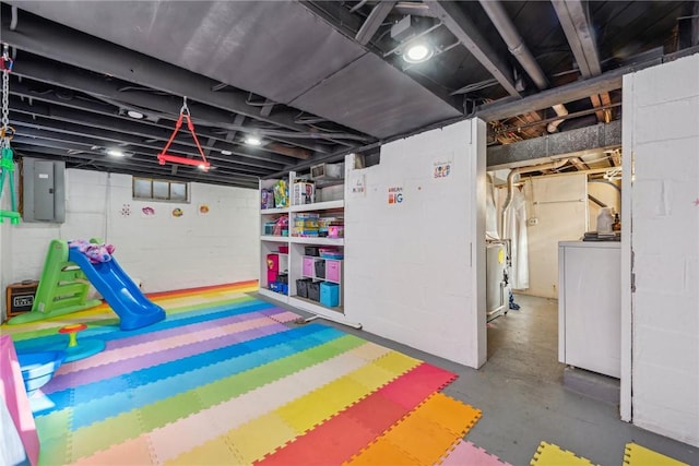 playroom with electric panel, concrete floors, and washer / clothes dryer