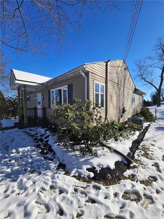 snow covered property featuring cooling unit