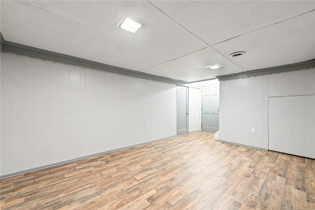 basement featuring wood walls and hardwood / wood-style flooring