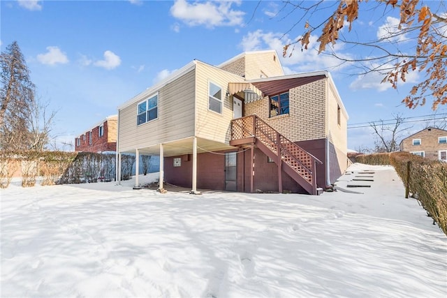 view of snow covered rear of property