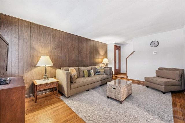 living room featuring wood-type flooring and wooden walls