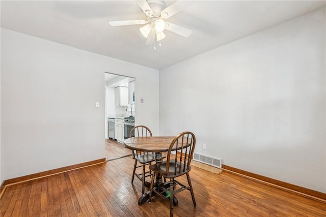 dining area with sink, ceiling fan, and hardwood / wood-style floors