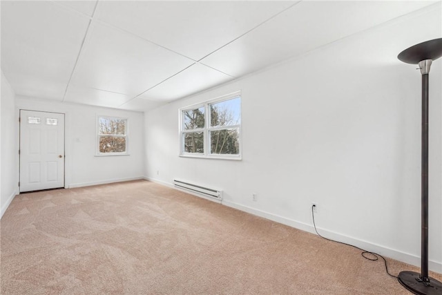 carpeted empty room with a baseboard heating unit