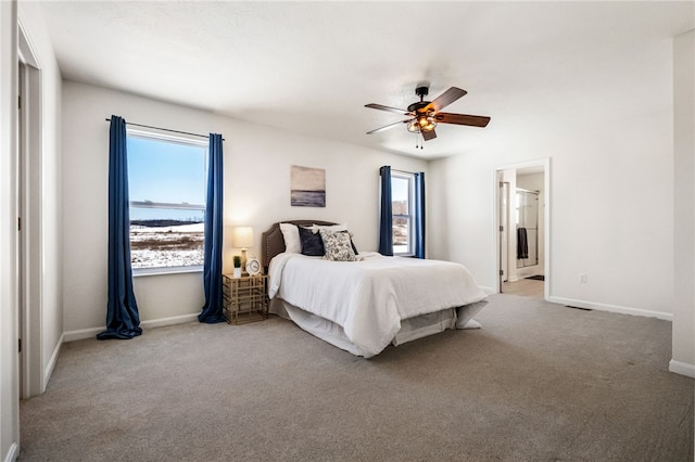 carpeted bedroom with ceiling fan and ensuite bath