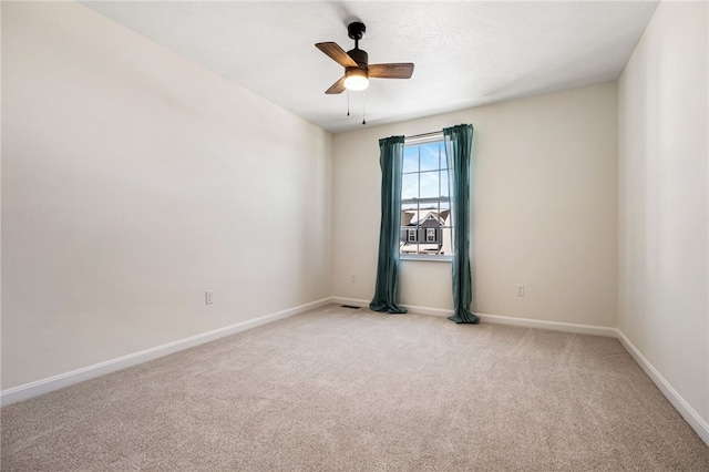 spare room with ceiling fan and light colored carpet