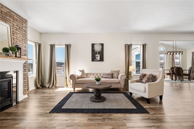 living room featuring a fireplace, wood-type flooring, and plenty of natural light