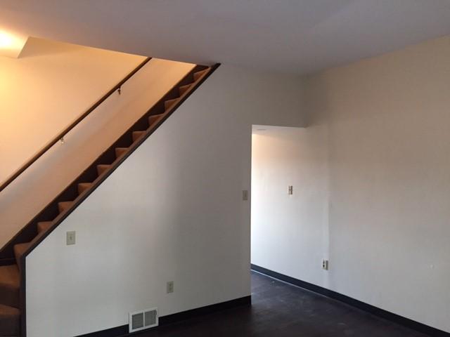 interior space featuring visible vents, baseboards, and stairway