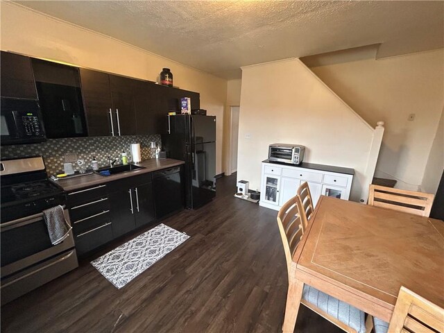 kitchen with dark wood-style flooring, a toaster, a textured ceiling, decorative backsplash, and black appliances
