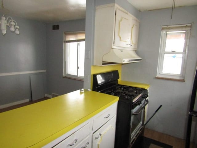 kitchen with white cabinets and black gas stove