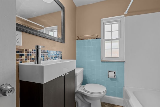 full bathroom with tile walls,  shower combination, vanity, and toilet