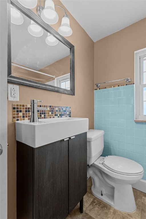 bathroom featuring tile walls, vanity, and toilet