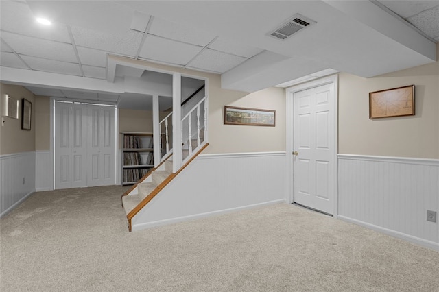 basement with carpet floors and a paneled ceiling