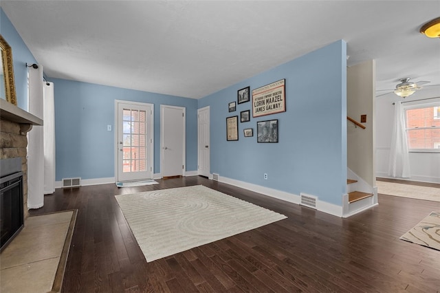 entrance foyer with a fireplace, ceiling fan, and dark hardwood / wood-style floors