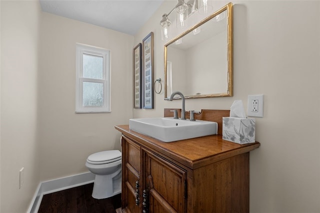 bathroom with toilet, vanity, and hardwood / wood-style flooring