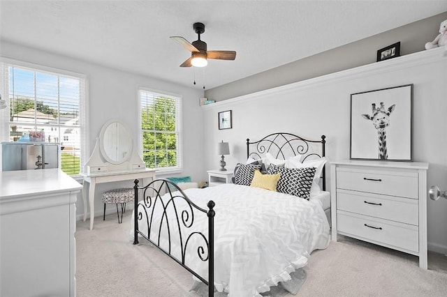 carpeted bedroom featuring ceiling fan and multiple windows