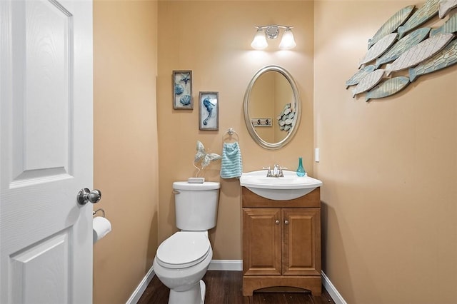 bathroom featuring toilet, vanity, and hardwood / wood-style flooring