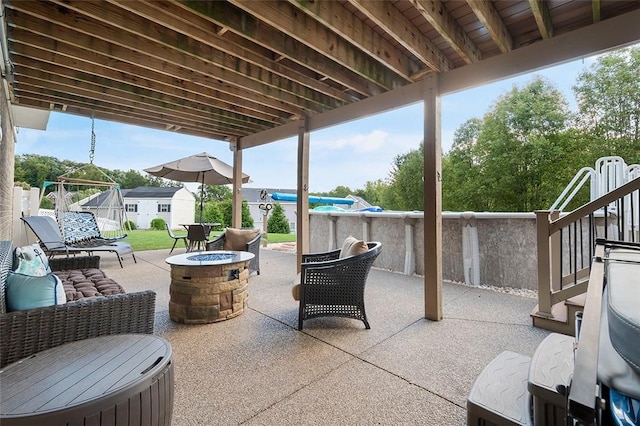 view of patio featuring an outdoor fire pit and a storage shed