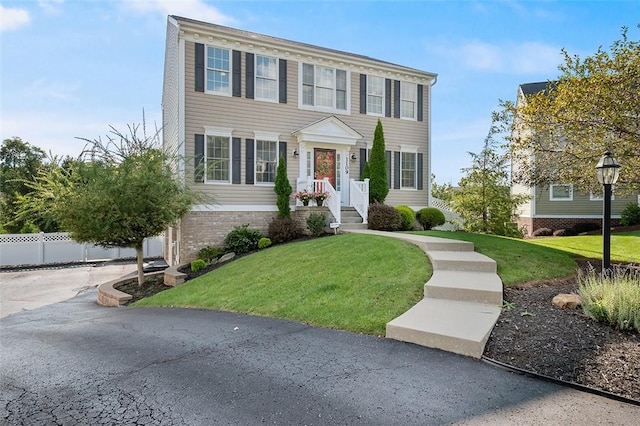 colonial inspired home featuring a front yard