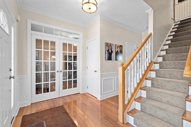 foyer entrance featuring french doors, crown molding, and hardwood / wood-style floors