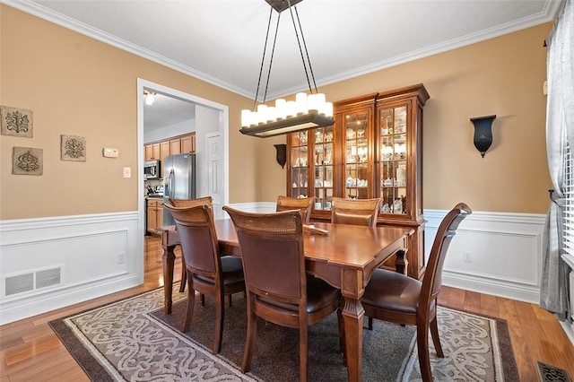 dining room with ornamental molding and hardwood / wood-style floors