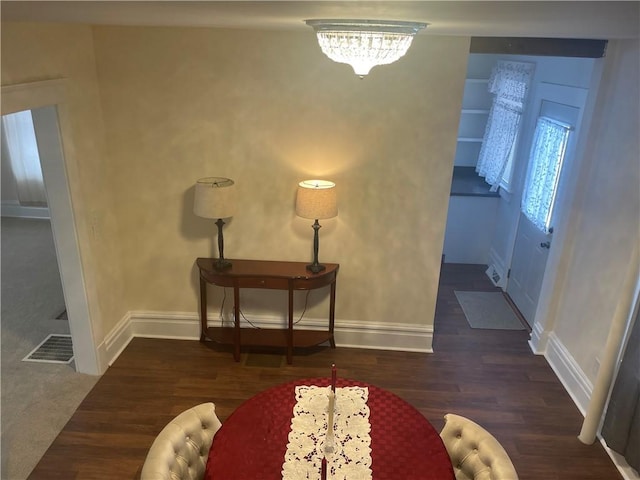 foyer featuring wood finished floors, visible vents, and baseboards