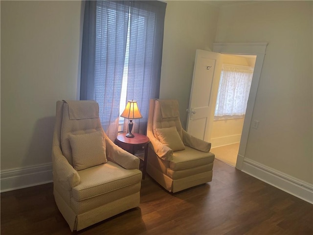 sitting room with baseboards and wood finished floors