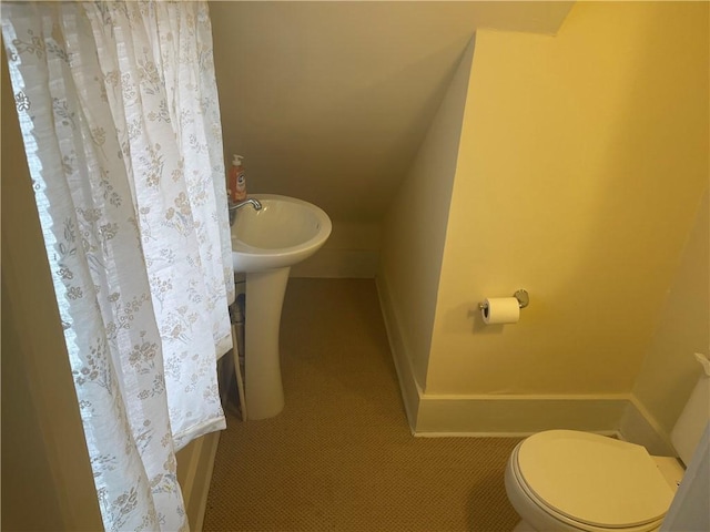 half bathroom featuring toilet and baseboards