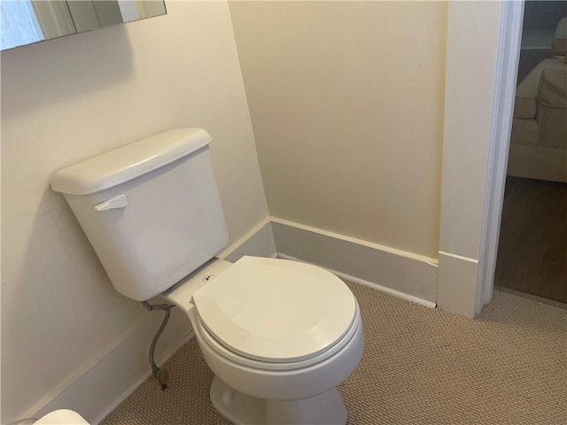 bathroom with toilet and baseboards