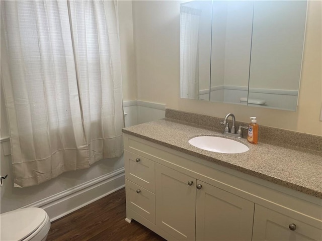 bathroom featuring toilet, wood finished floors, and vanity