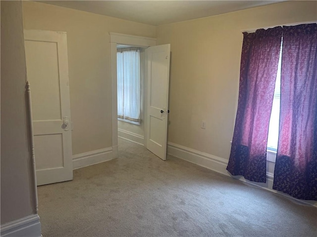 carpeted empty room featuring baseboards