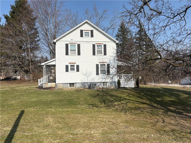 rear view of property with central air condition unit, a lawn, and covered porch