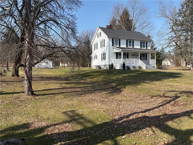 view of front of property featuring a porch, a front lawn, and a chimney