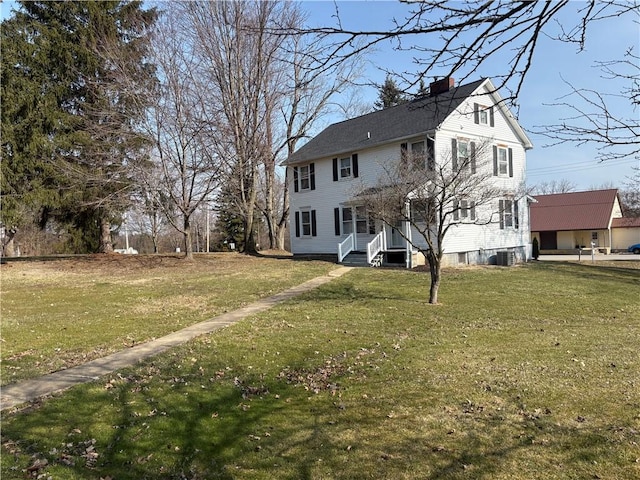 exterior space with a chimney, central AC, and a front yard