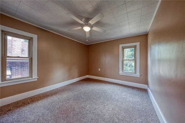 empty room with crown molding, ceiling fan, a healthy amount of sunlight, and carpet floors