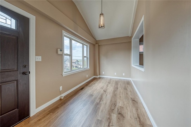 foyer entrance featuring vaulted ceiling and light hardwood / wood-style flooring