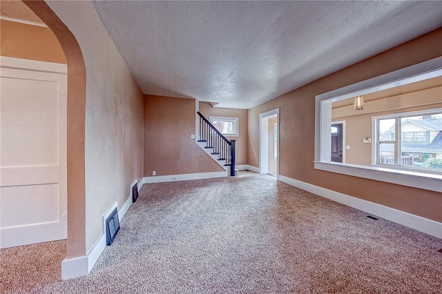 interior space with carpet floors and a textured ceiling