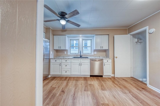 kitchen with sink, light hardwood / wood-style flooring, stainless steel appliances, light stone counters, and white cabinets