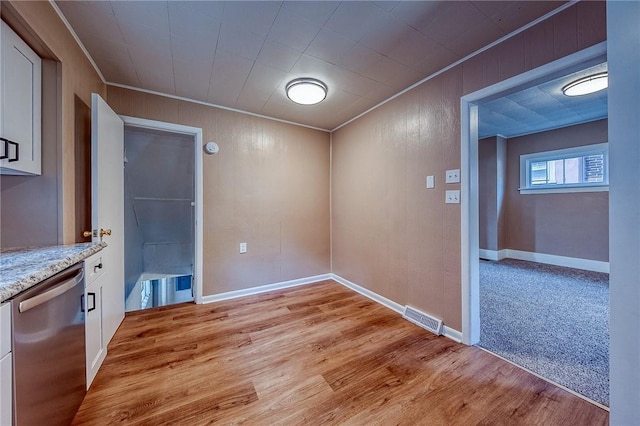 unfurnished dining area with wooden walls and light carpet