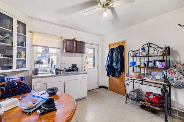 kitchen with white cabinets, ceiling fan, and sink