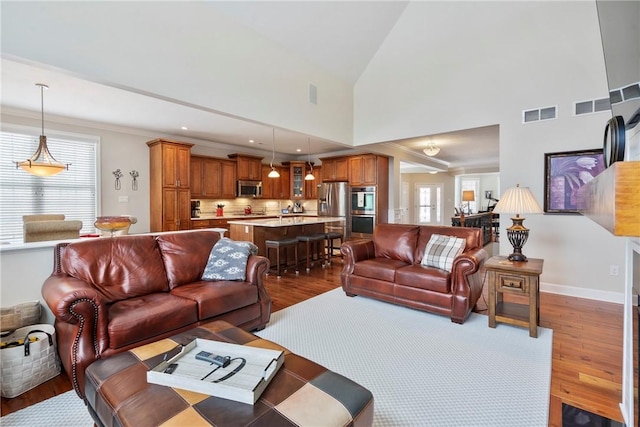 living room with high vaulted ceiling and dark hardwood / wood-style flooring