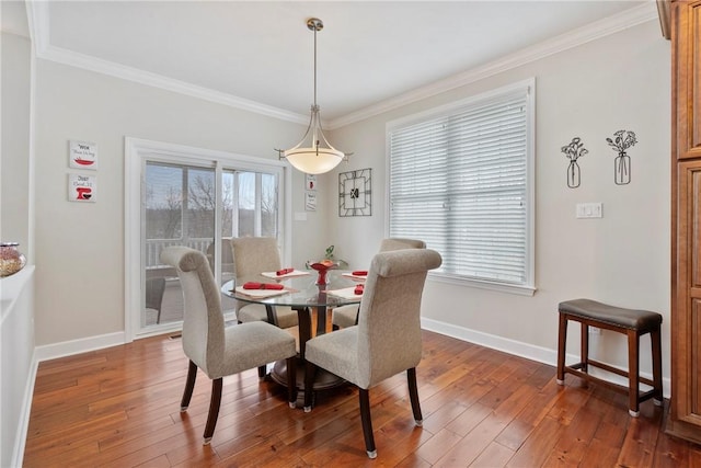 dining space with plenty of natural light, ornamental molding, and dark hardwood / wood-style floors