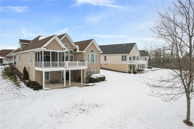 snow covered property with a sunroom